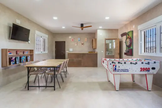 Zona interior de El Recreo de Alba con mesas de reuniones y chimenea